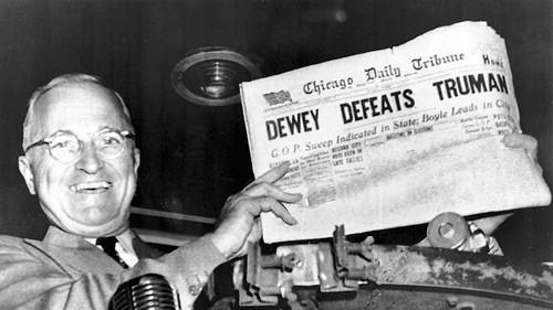 Fíor 3.6: An tUachtarán Harry Truman ag gabháil le ceannlíne nuachtáin a d'fhógair go mícheart a chosc. Bhí an ceannlíne seo bunaithe i bpáirt ar mheastacháin ó shamplaí neamhchóchúiseachta (Mosteller 1949; Bean 1950; Freedman, Pisani, and Purves 2007). Cé gur tharla Dewey Defeats Truman i 1948, tá sé fós i measc an chúis go bhfuil roinnt taighdeoirí skeptical faoi mheastacháin ó shamplaí nach dóchúlacht. Foinse: Leabharlann agus Músaem Harry S. Truman.